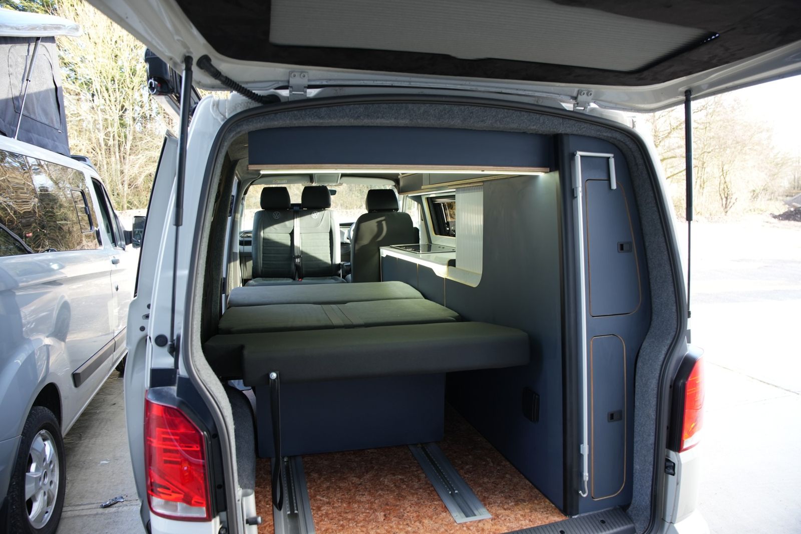 Bed from the rear doors: Full-width bed with storage below.